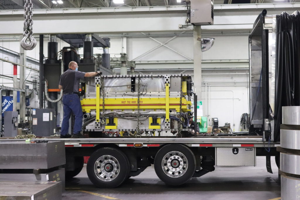 employee working on machine equipment on trailer bed